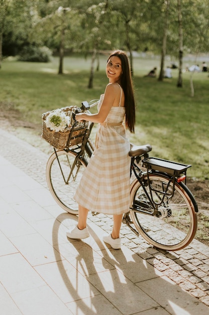 Jovem com flores na cesta de bicicleta elétrica