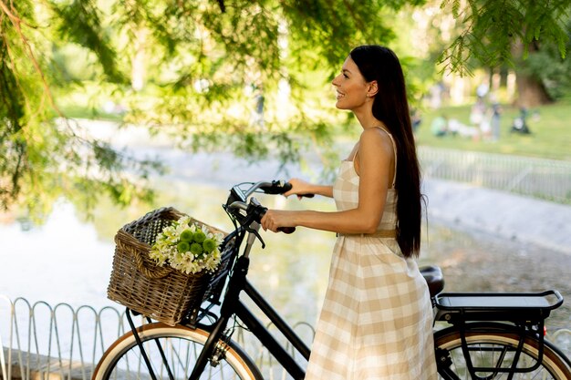 Jovem com flores na cesta de bicicleta elétrica