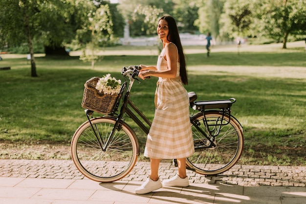 Jovem com flores na cesta de bicicleta elétrica