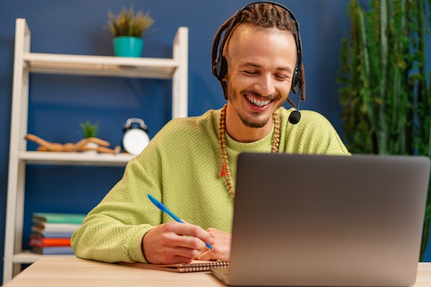 Foto jovem com fone de ouvido, olhando para a câmera do laptop. conceito de consultor de serviço