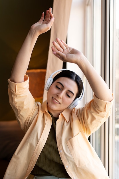 Foto jovem com fones de ouvido e dançando