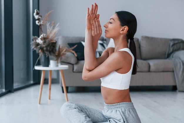 Jovem com forma de corpo esbelto em roupas esportivas tem dia de fitness dentro de casa em casa