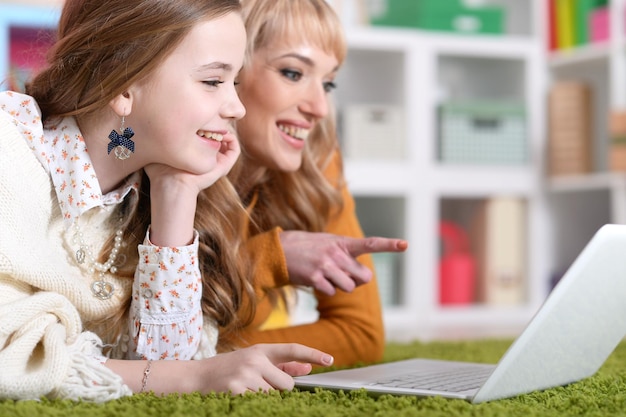 Jovem com garota usando laptop em casa no chão