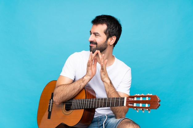 Jovem com guitarra sobre isolado planejando algo