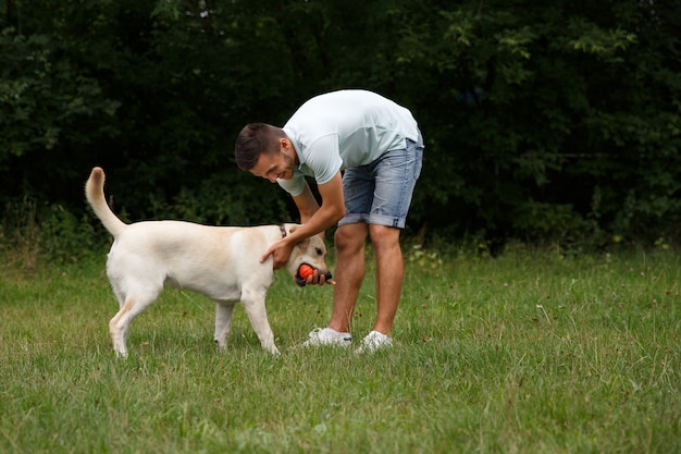 Jovem com labrador feliz no parque