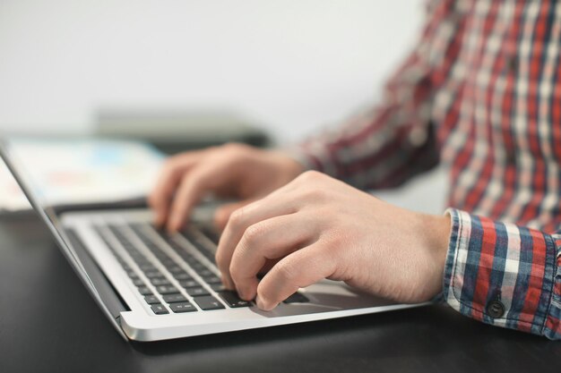 Jovem com laptop trabalhando no escritório