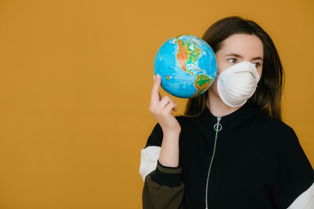 Jovem com máscara facial protetora segurando o globo