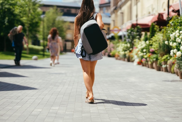 Jovem com mochila caminha pela cidade