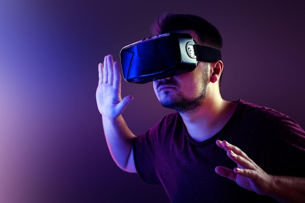 Jovem com óculos de realidade virtual perto de lâmpadas fluorescentes brilhantes