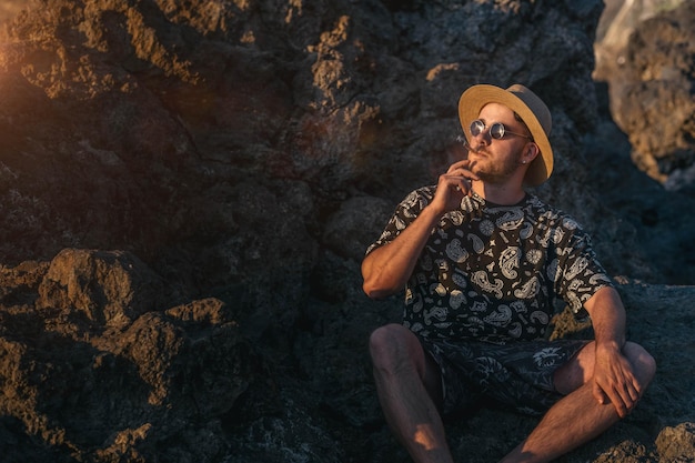 Jovem com óculos de sol fumando um baseado