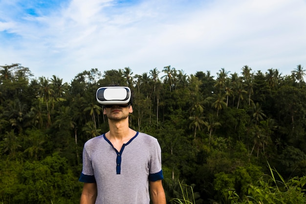 Jovem com óculos Vr na floresta tropical