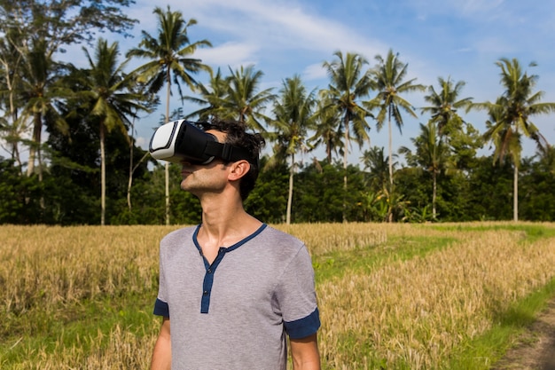 Jovem com óculos Vr no campo de arroz tropical