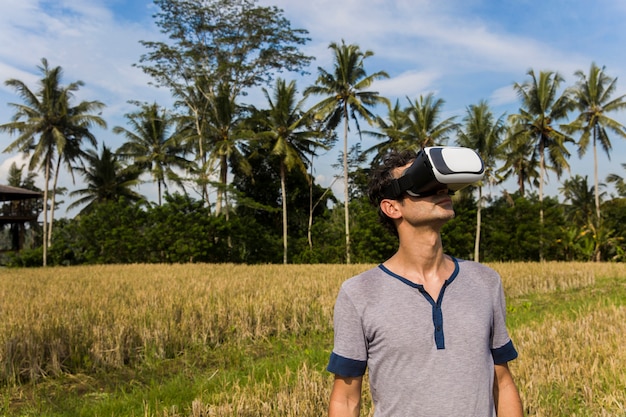 Jovem com óculos Vr no campo de arroz tropical