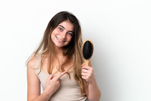 Jovem com pente de cabelo isolado no fundo branco e apontando-o