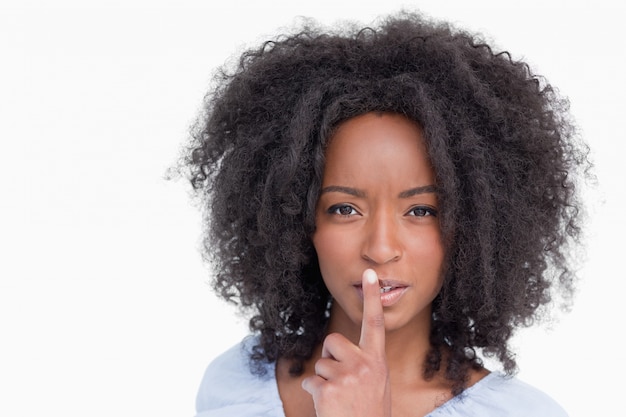 Jovem com penteado curly dizendo para ficar quieto