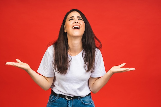 Jovem com raiva estressada irritada elegante elegante mulher gritando gritando isolado no estúdio de fundo de cor vermelha Conceito de estilo de vida de pessoas