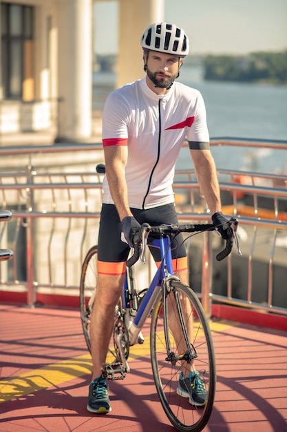 Jovem com roupas esportivas com uma bicicleta