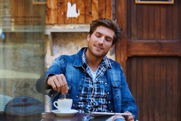 Jovem com tablet pc toque em um café