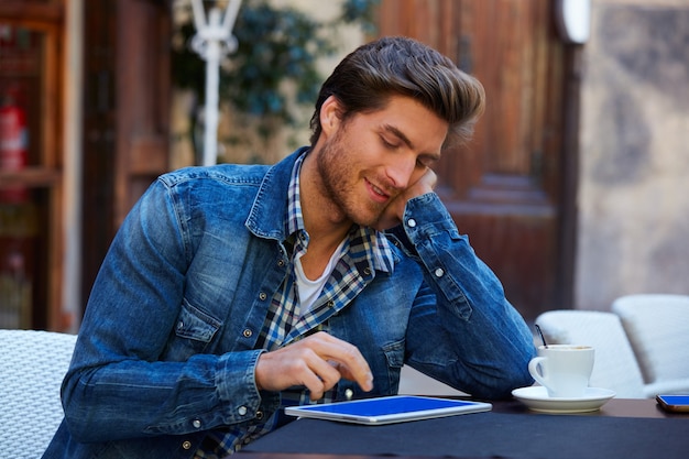 Jovem com tablet pc toque em um café