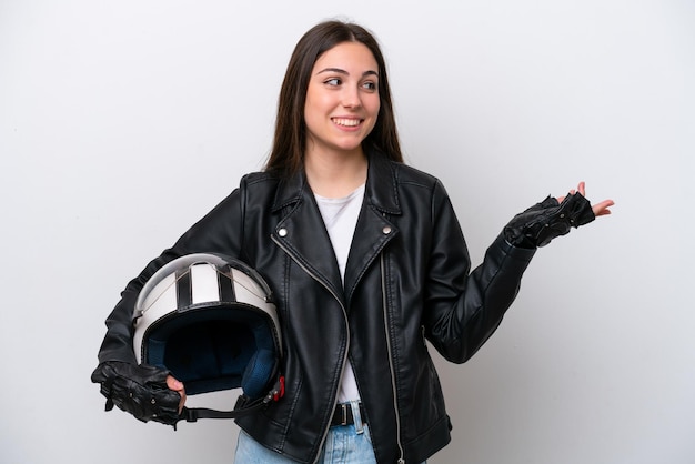 Jovem com um capacete de moto isolado no fundo branco, estendendo as mãos para o lado para convidar para vir