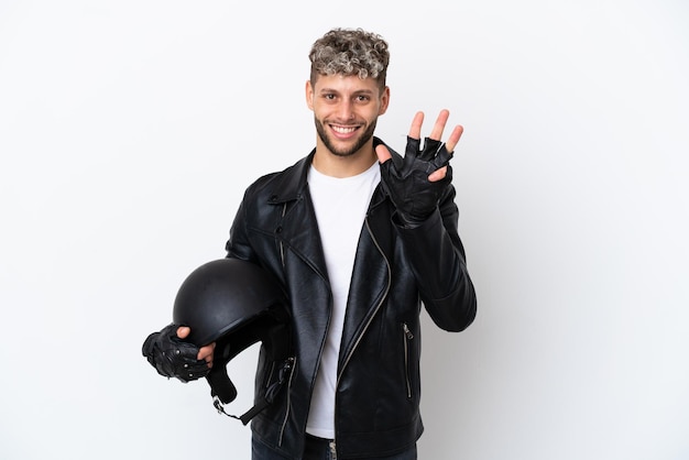 Jovem com um capacete de motociclista isolado no fundo branco feliz e contando quatro com os dedos