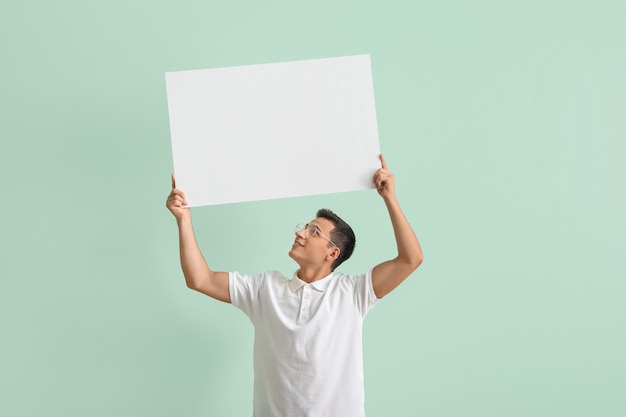 Jovem com um cartaz em branco no verde