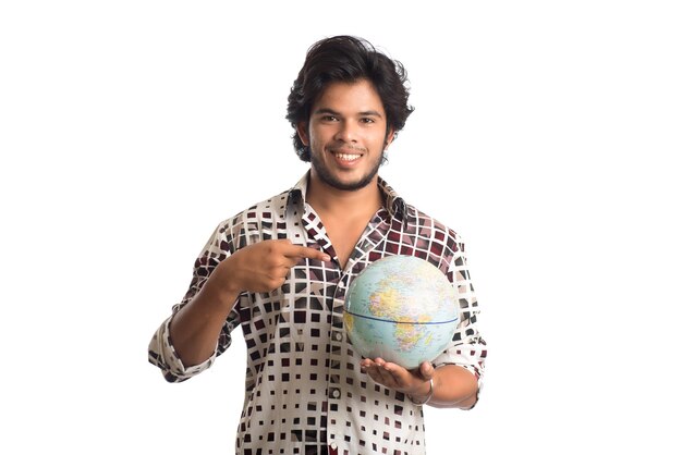 Jovem com um globo do mundo em um branco.