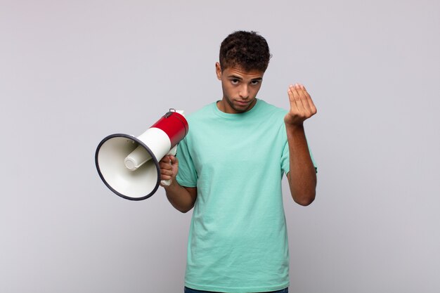 Jovem com um megafone fazendo capice ou gesto de dinheiro, mandando você pagar suas dívidas!