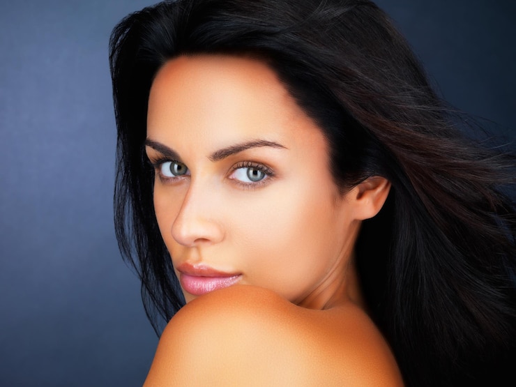 Foto jovem com um rosto bonito close de uma linda mulher olhando para você no fundo azul