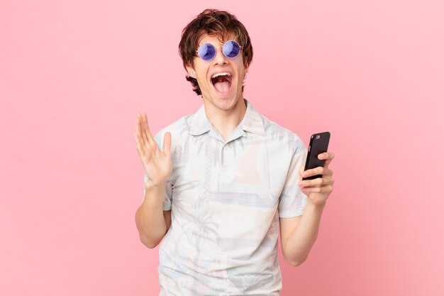 Jovem com um telefone celular se sentindo feliz e surpreso com algo inacreditável