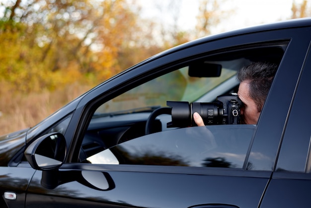 Jovem com uma câmera dslr em um carro