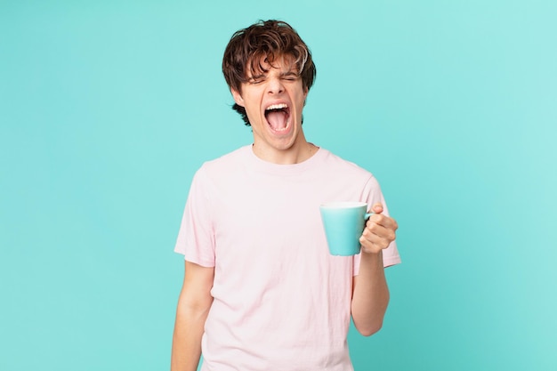 Jovem com uma caneca de café gritando agressivamente, parecendo muito zangado