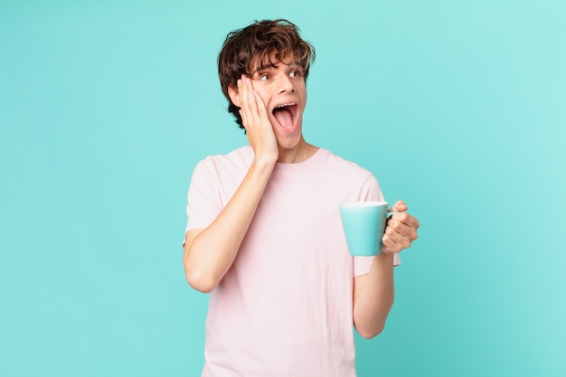 Jovem com uma caneca de café se sentindo feliz, animado e surpreso