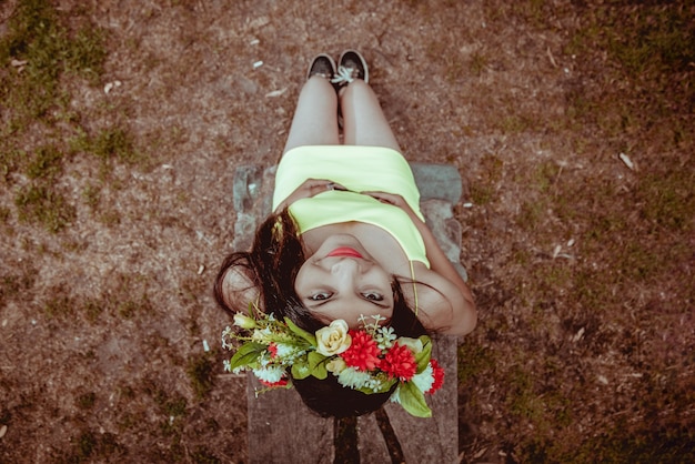 Jovem com uma coroa de flores na paisagem natural