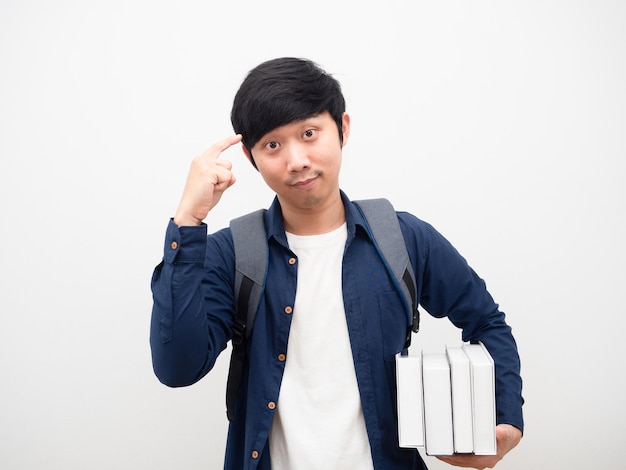 Jovem com uma mochila escolar segurando livros e apontando para a cabeça dele por pensar em um fundo branco