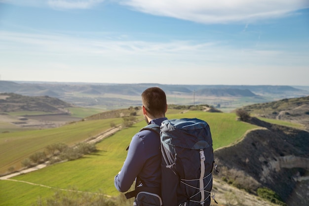 Jovem com uma mochila olhando a paisagem