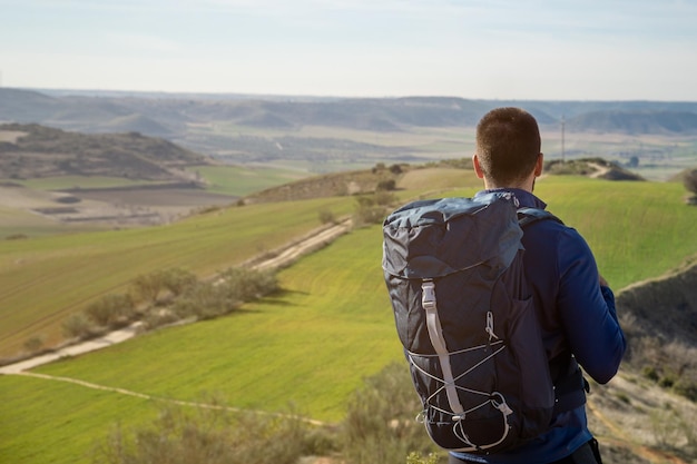 Jovem com uma mochila olhando a paisagem