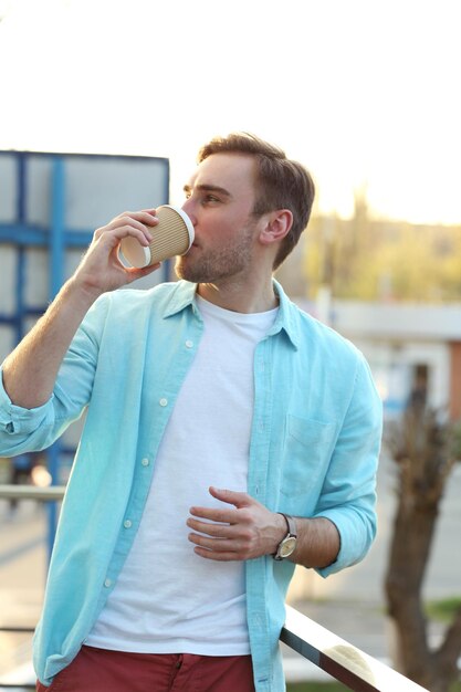 Foto jovem com uma xícara de café ao ar livre