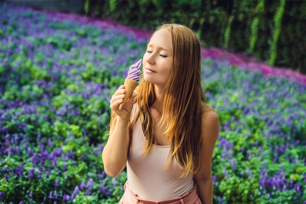 Jovem come sorvete de lavanda em um fundo de campo de lavanda