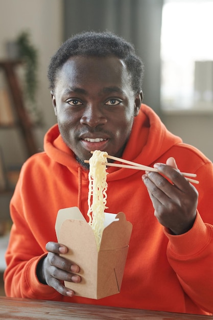 Jovem comendo macarrão