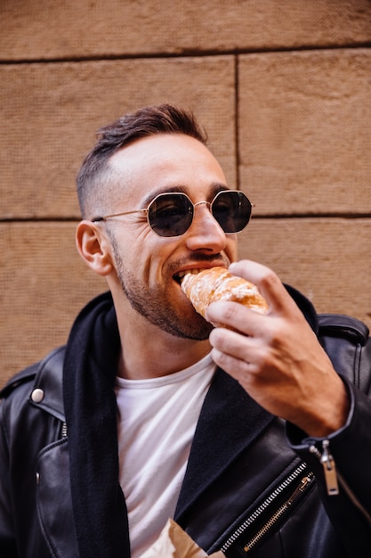 Jovem comendo na rua