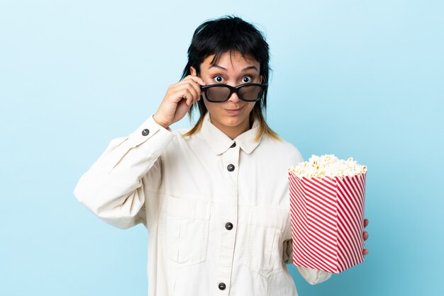 Jovem comendo pipocas sobre fundo isolado