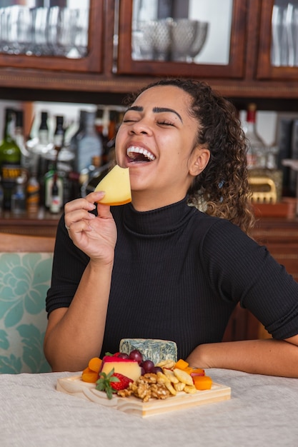 Jovem comendo queijo. mulher comendo salgadinhos de queijo