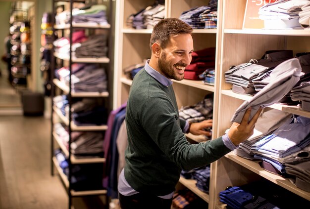 Foto jovem comprando roupas na loja