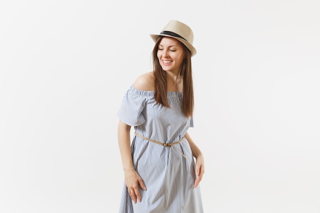 Jovem concurso elegante encantadora mulher vestida de vestido azul, chapéu bonito com longos cabelos castanhos posando isolado no fundo branco. pessoas, emoções sinceras, conceito de estilo de vida. área de publicidade. copie o espaço.