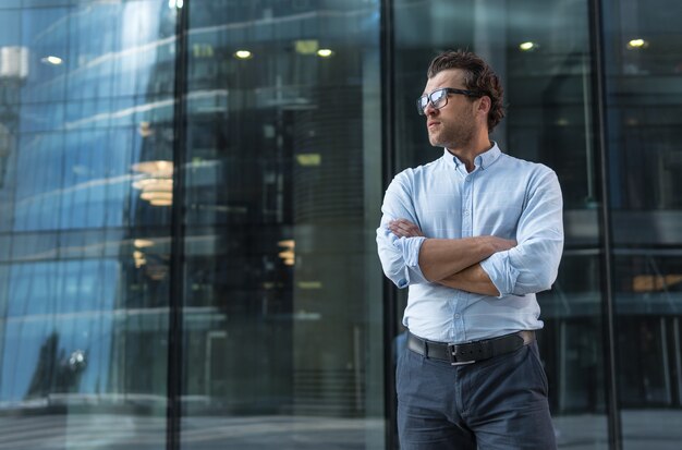 Jovem confiante em pé contra um edifício moderno