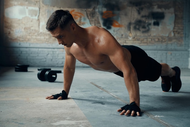 Foto jovem confiante fazendo exercícios de flexão no ginásio