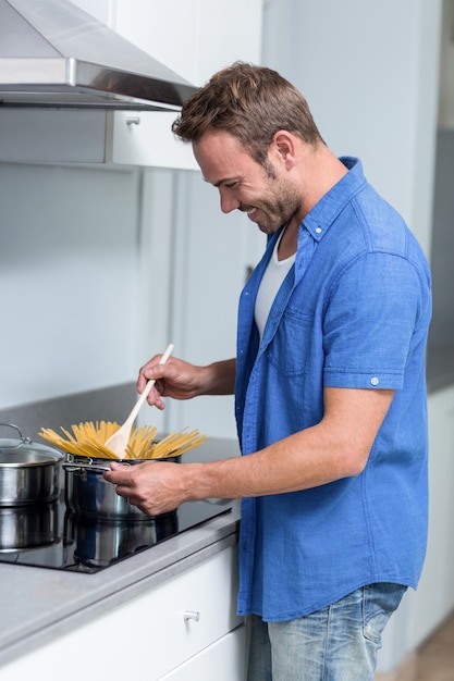 Jovem cozinhar espaguete