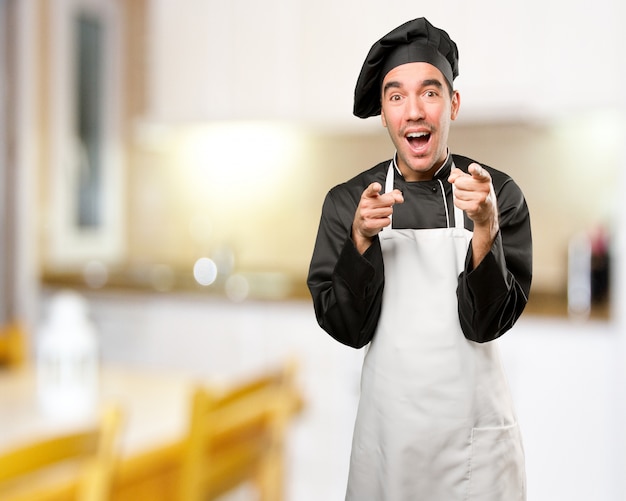 Jovem cozinheiro engraçado rir de você