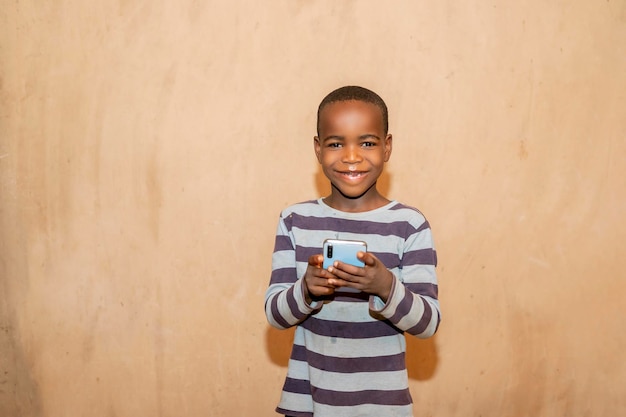 Jovem criança africana jogando jogo para celular no telefone inteligente